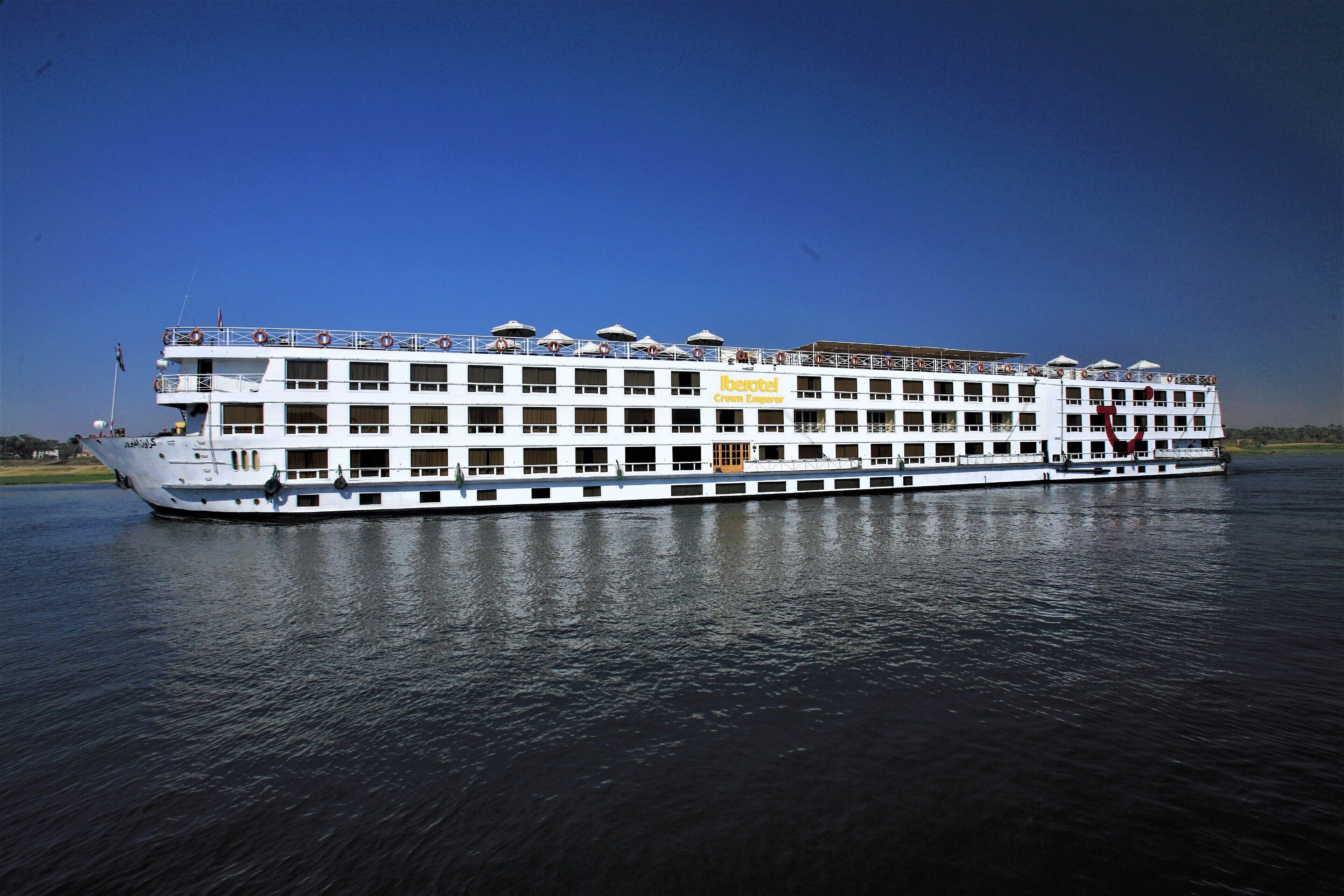 A large, multi-deck cruise ship with balconies and a 'Hotel' sign on the side.