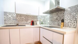 Eine moderne Küche mit weißer Arbeitsplatte, einem gemusterten Rückwand und hellen Schränken.