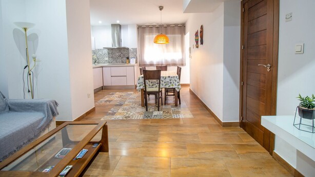 Ein modernes Wohnzimmer mit einer Couch, einem Couchtisch und einem Essbereich mit Tisch und Stühlen.