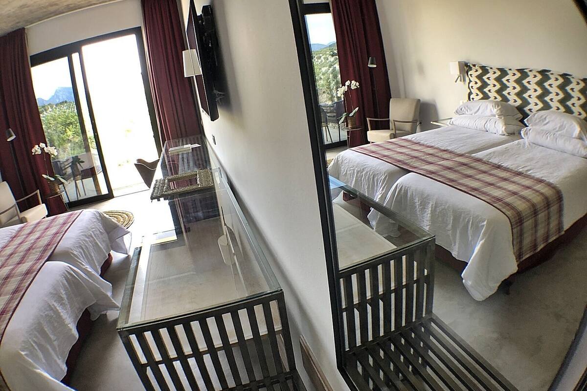 Une chambre d’hôtel avec deux lits, un balcon, une télévision et une vue sur l’extérieur.