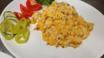 Ein Teller mit Rührei, Tomatenscheiben, Gurkenscheiben und Paprikastreifen.