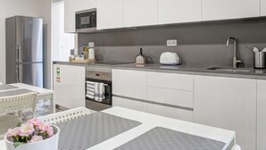 Eine moderne Küche mit Edelstahlgeräten, einer Mikrowelle und einem Wasserkocher.