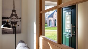 Huoneesta avautuu näkymä vihreään oveen, lamppuun ja Eiffel-tornin julisteeseen.