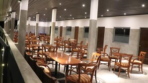 A spacious indoor dining area with wooden tables and chairs, high ceilings with recessed lighting, and a modern architectural design. - Rest House Tangalle (Tangalle)