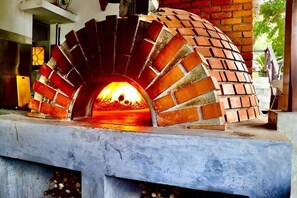 A brick oven with a fire burning inside, placed on a concrete base. - Rest House Tangalle (Tangalle)