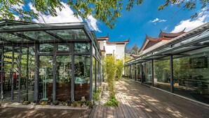 A modern building with glass structures and a wooden deck. - Leliving Butterfly Resort Lijiang (Lijiang)