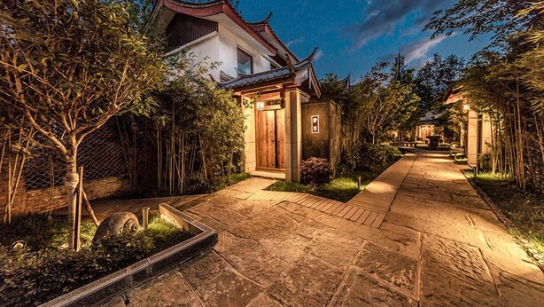 A traditional building with a tiled roof and a wooden door, surrounded by greenery and a stone pathway. - Leliving Butterfly Resort Lijiang (Lijiang)