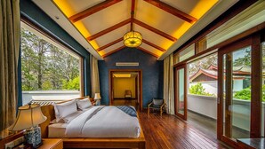 A spacious bedroom with a large bed, wooden flooring, and a view of greenery outside. - Leliving Butterfly Resort Lijiang (Lijiang)