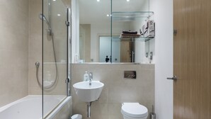 A modern bathroom with a glass-enclosed shower, a white sink, and a toilet. - Beautiful 1 bedroom apartment (Croydon)