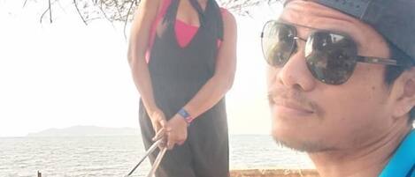 A person grilling outdoors near a body of water.