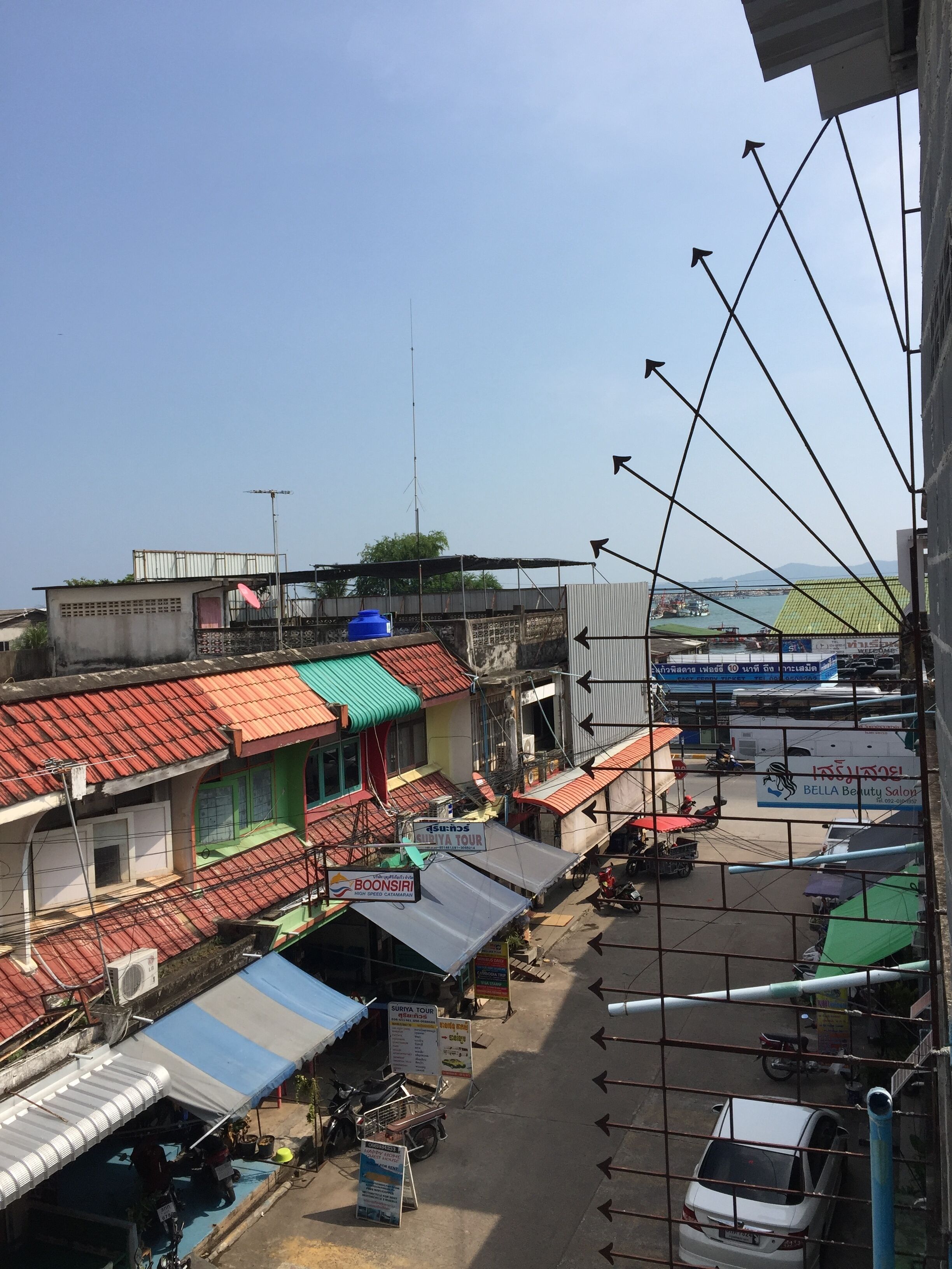 A street view with various shops and a parking area.