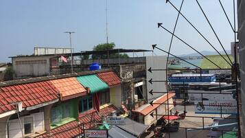 A street view with various shops and a parking area.
