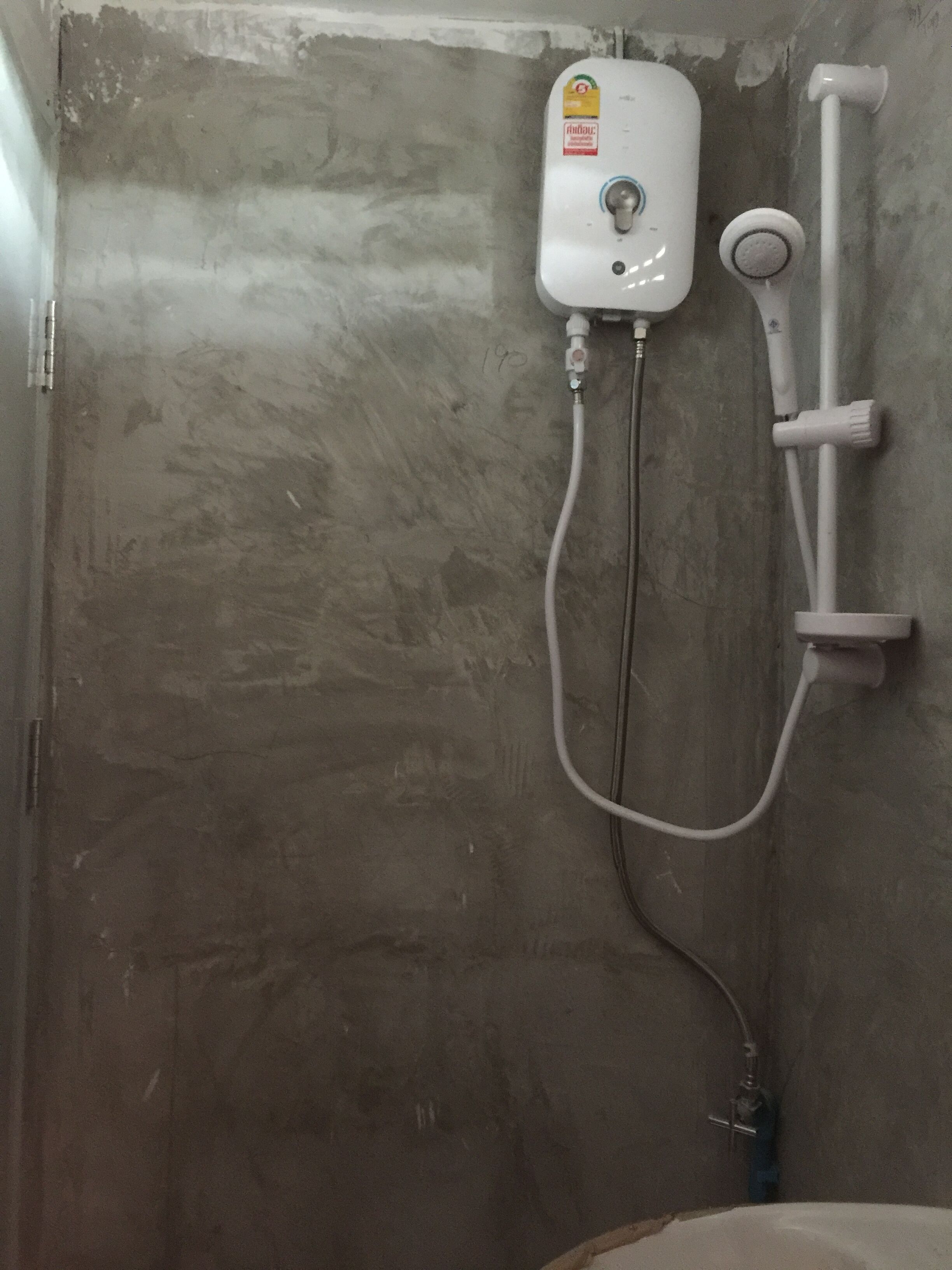 Ducha con panel de control y cabezal de ducha de mano fijo en la pared.