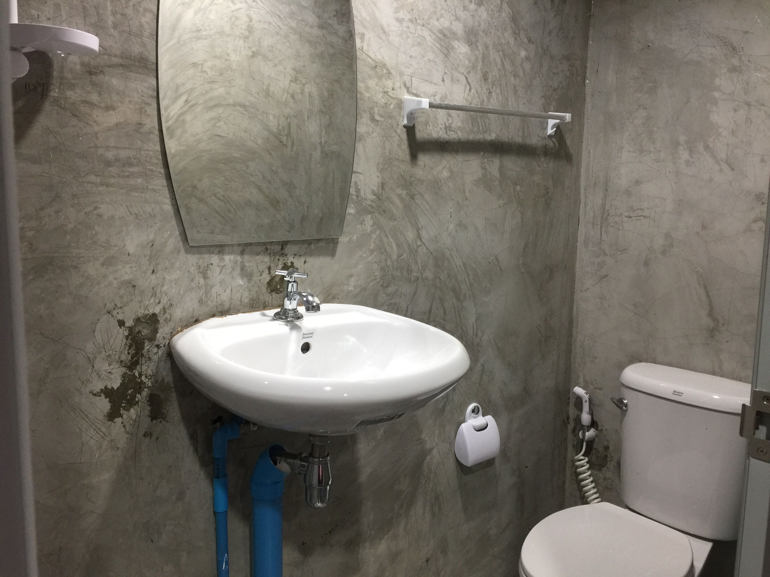 A bathroom with a white sink, a toilet, and a mirror.
