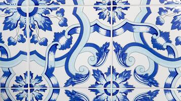 A tiled wall with a blue and white floral pattern.