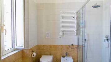 Ein Badezimmer mit Toilette, Bidet und einer Duschkabine.