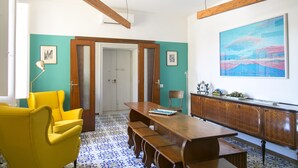 Un espace repas avec une table en bois, des chaises jaunes et un sol à motifs bleus.