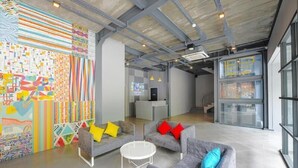 An open-plan office space with a modern design, featuring a mix of seating areas and a reception desk. - The Social House - Coliving & Hostel (Jakarta)
