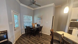 A dining area with a wooden floor, a ceiling fan, and a dining table with chairs. - Modern Home in Excellent Location!! (Fort Worth)