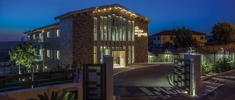 Vista frontal de la propiedad por la tarde o noche