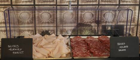 A display case with sliced turkey breast and sliced salami.