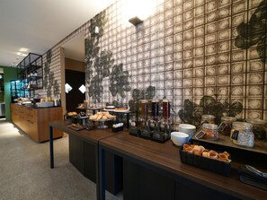 A breakfast buffet with various food items and beverages, a coffee station, and a counter with utensils. - Best Western Plus Dimora del Monaco (Matera)