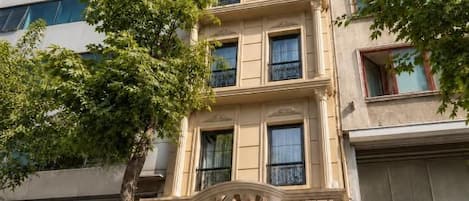 Un hotel de varios pisos con una fachada clásica, una entrada destacada y un letrero que indica que es el Grand Kaval Hotel.