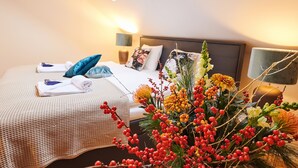 Une chambre d’hôtel avec un lit, une table de chevet, une lampe et une grande fenêtre.
