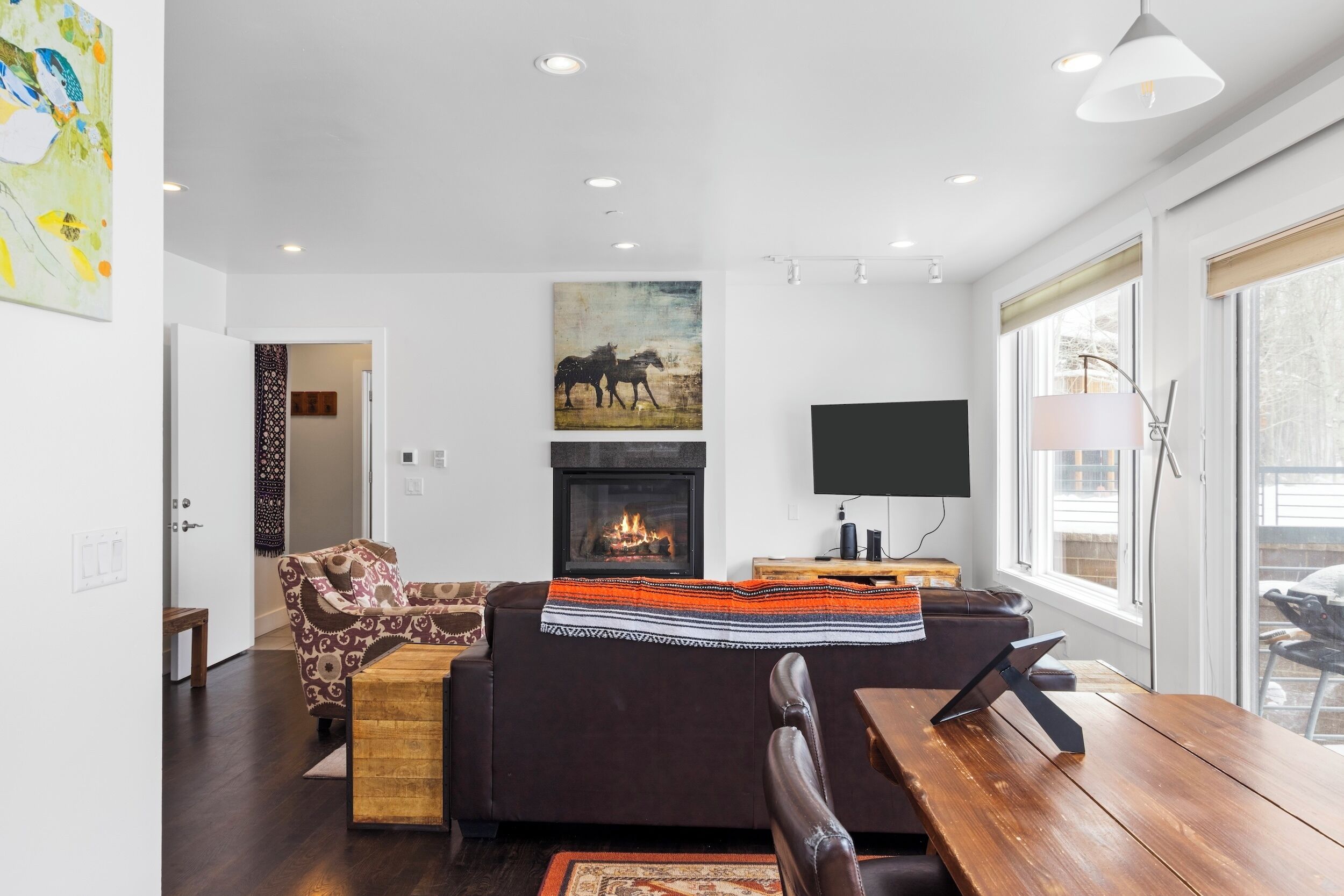 A modern living room with a fireplace, a sofa, a coffee table, and a TV.