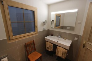 Bathroom features a single sink, mirror, and towel rack.