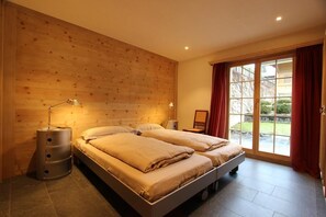 Relax in a serene bedroom with a large bed, bedside tables, and a sliding door to an outdoor area.
