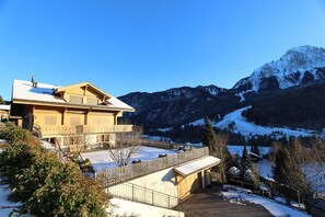 Situated in a mountainous area, this traditional building offers a balcony with a view of the surrounding evergreen trees and distant mountains.
