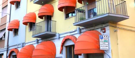 A multi-story building with balconies featuring orange awnings.