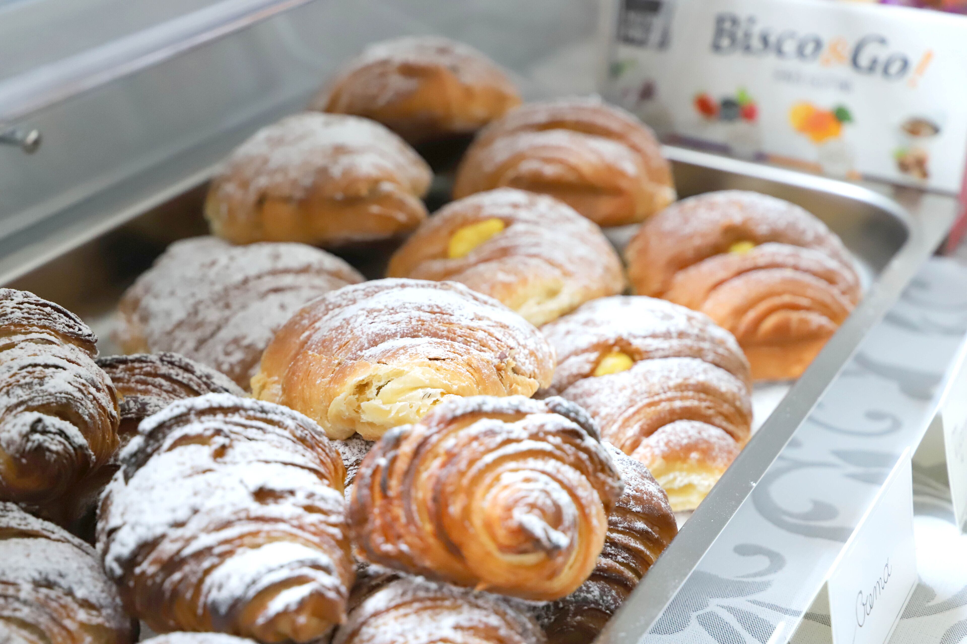 Eine Auswahl an Gebäckstücken, darunter Croissants und Dänisch, in einer Bäckerei.
