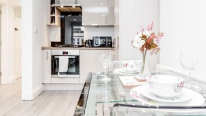 A modern kitchen with white cabinets, a microwave, and a coffee maker. - Flat 5 · Stunning 2-Bed Notting Hill Portobello Apartment (London)