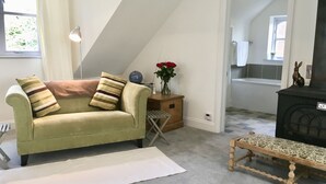 Una sala de estar acogedora con un sofá verde, una mesita de madera y un banco.