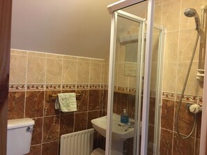 Een bad/douchecombinatie, een haardroger, handdoeken, zeep