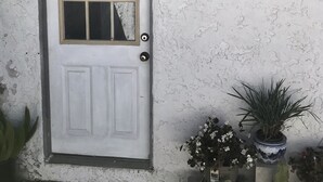 A white door with a window, a doorknob, and a small potted plant beside it. - Entire 3 bedrooms guest property, near Pacific Beach, Downtown，Seaworld，LaJolla (San Diego)