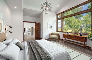 Een moderne slaapkamer met een bed, een stoel, een houten dressoir en een groot raam met uitzicht op bomen.