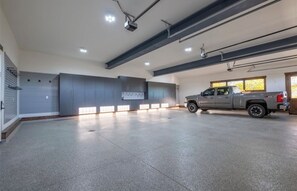 Un grand garage dans lequel est garé un pick-up gris.