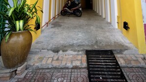 A yellow entrance with a sign for 'homestay & coffee' and a motorcycle parked inside. - K2 Homestay & Coffee - Hostel (Can Tho)