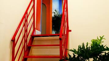 Un escalier avec des rampes rouges menant à un palier.