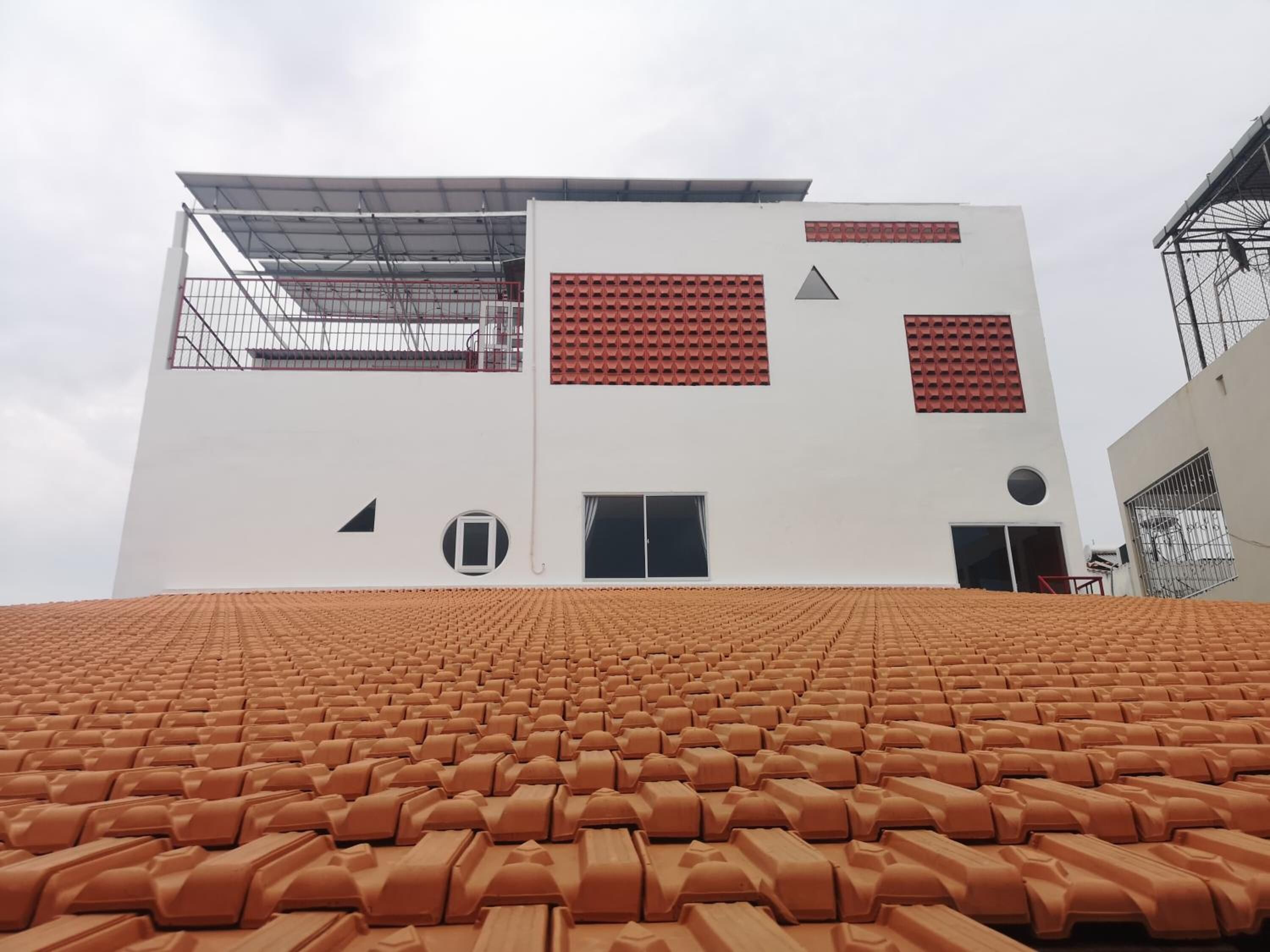 A modern building with a flat roof and a white facade.