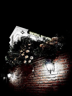 A hotel sign with "HOTEL ROSETO" illuminated at night, surrounded by climbing roses and brick walls. - Pocheon Hotel Roseto (Pocheon)