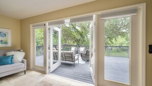 A room with a sliding glass door leading to an outdoor deck with patio furniture. - ✨River Front✨Heated Pool Estate-Large Group,Busch Garden,USF, Sleeps 14 (Tampa)