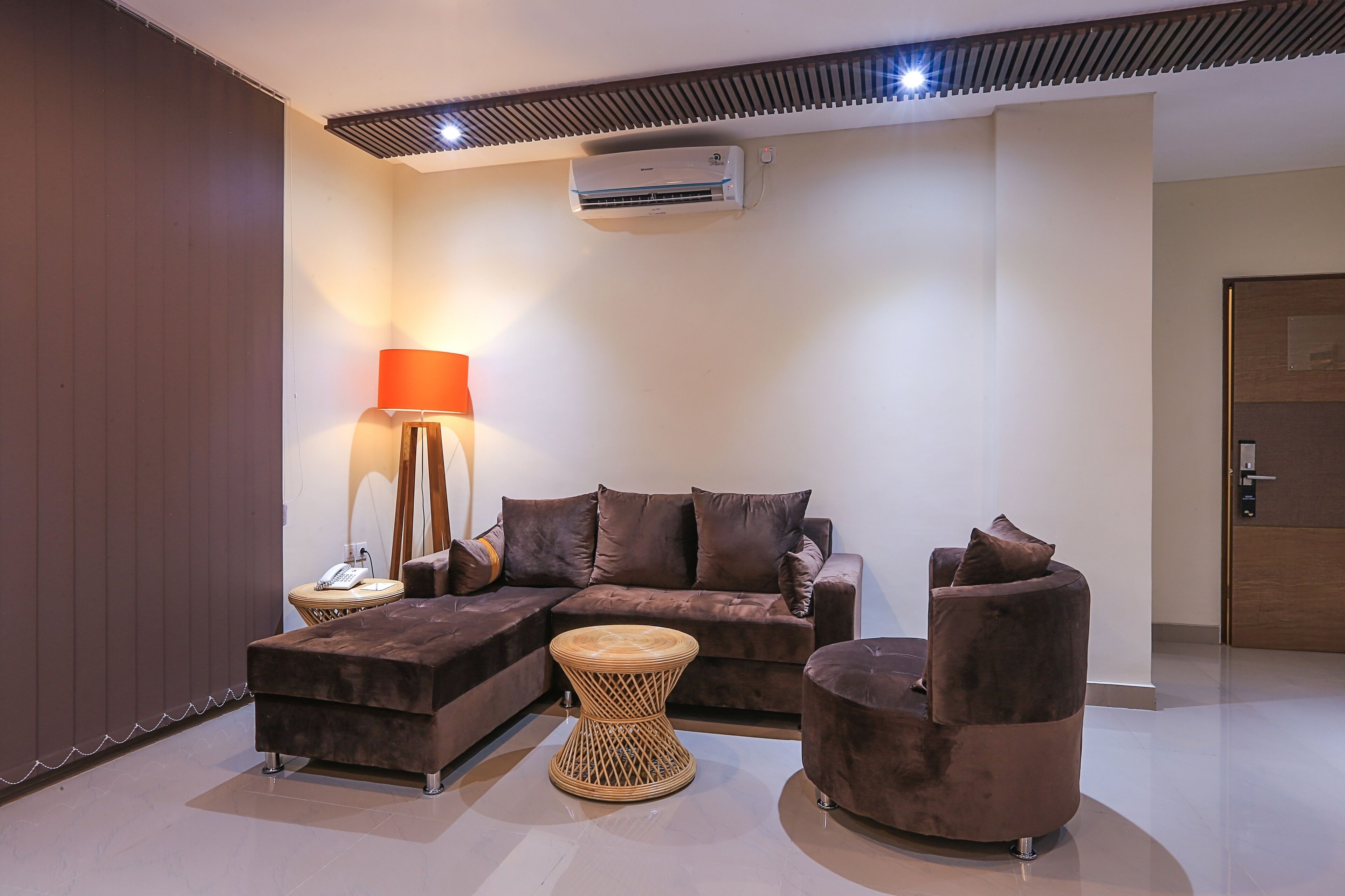 A modern living room with a sectional sofa, a round coffee table, and a chaise lounge.