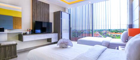 A modern hotel room with a large bed, a TV, a wardrobe, and a balcony with a city view.