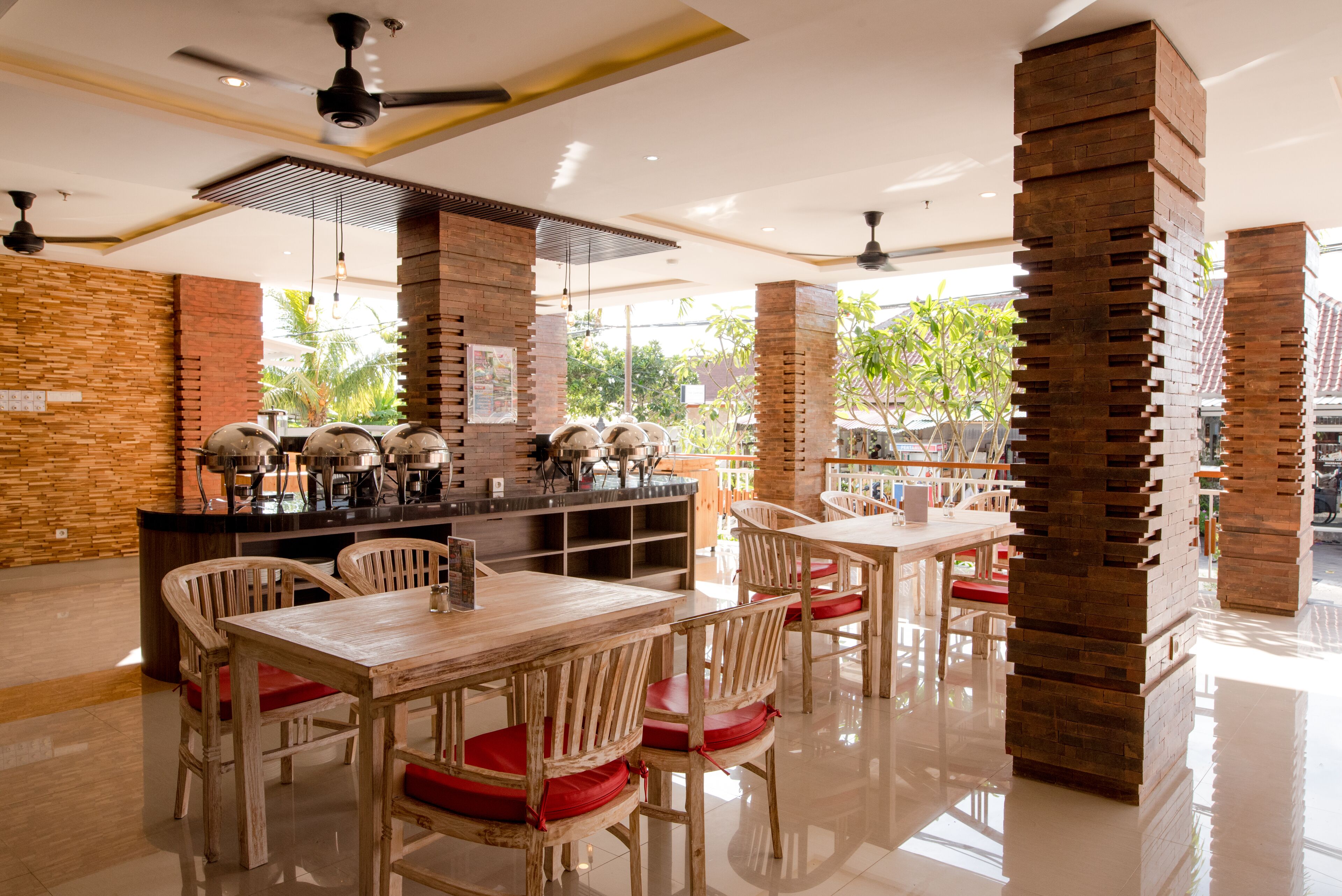 A restaurant with wooden tables and chairs, a brick column, and a counter with a menu.