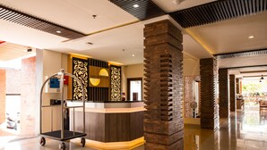 Uma área de recepção com balcão, carrinho e painel decorativo.