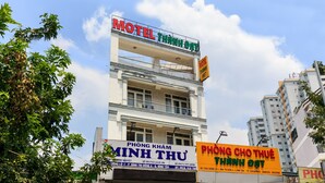 Un immeuble à plusieurs étages, sur lequel on peut voir une grande enseigne indiquant « Motel Thanh Dat » au sommet.